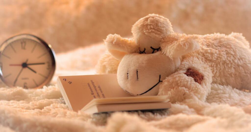 ぬいぐるみがベッドの上で眠る画像